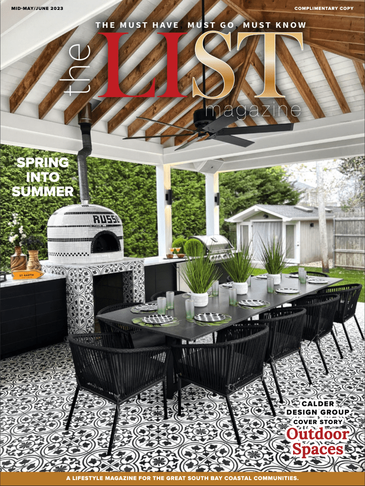 Outdoor patio with a dining set, brick oven, and decorative tile floor under a wooden pergola.